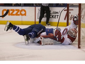 Maple Leafs centreman Leo Komarov bowls over Canadiens goaltender Carey Price as Toronto beat the Canadiens at the Air Canada Centre on Saturday, April 7, 2018.
