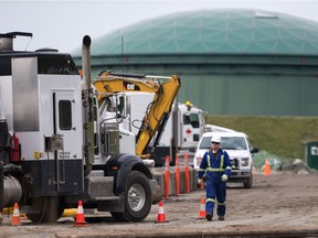 A worker walks past heavy equipment as work continues at Kinder Morgan's facility in preparation for the expansion of the Trans Mountain Pipeline, in Burnaby, B.C., on Monday April 9, 2018.