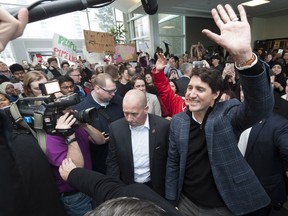 Prime Minister Justin Trudeau makes his way through the crowds as people hold oil pipeline protest signs at the University of Regina on Thursday January 26, 2017.