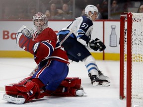 Montreal Canadiens goaltender Carey Price looks back as Winnipeg Jets defenceman Tyler Myers looks in to the net after Winnipeg Jets Kyle Connor scored the overtime winner in Montreal on April 3, 2018.
