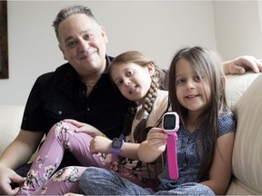 Adam Dorfman, seen at his Dollard home with his daughters Caleigh and Sierra, sells GPS tracking bracelets for children.