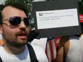 Influential Montreal-based neo-Nazi Zeiger holds up a hateful tweet during the Unite the Right rally in Charlottesville, Va., on August 12, 2017.