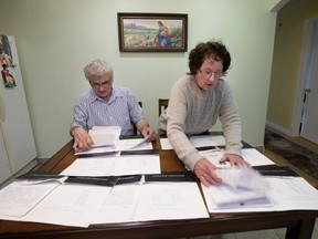 Ped and Zofia Malek shift through a pile of paperwork related to the repairs done in their flooded family home in Montreal