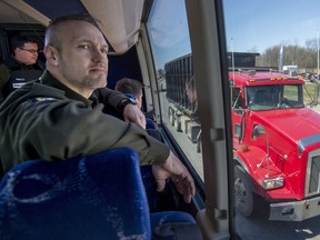 Sûreté du Québec officer Benoit Théoret looks for drivers texting, using a cellphone or not wearing a seat belt as he rides a bus along Highway 40 in Montreal on Tuesday, May 8, 2018.