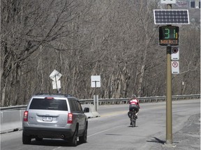A car and cyclist make their way down Camillien-Houde Way on Tuesday, May 8, 2018. The road will be closed for six Sunday mornings this summer  and fall as part of "cyclovia" events.