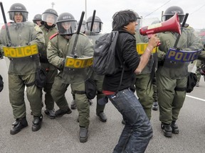 Immigrants rights activist Jaggi Singh is shoved by Surete de Quebec riot squad officers while leading a group of demonstrators blocking Highway 15 during demonstration near the Canada-USA border at Lacolle, south of Montreal Saturday May 19, 2018.  Singh was arrested moments later.  Pro-immigration demonstrators were at the border to counter a demonstration by right-wing group Storm Alliance.  (John Mahoney / MONTREAL GAZETTE) ORG XMIT: 60709 - 2340