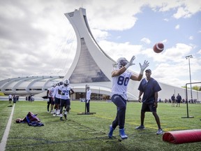 Reciever Seydou Junior Haidara catches the football under the eye of receivers coach Jason Tucker, right, during the first day of Alouettes training camp at the Olympic Stadium in Montreal on Sunday May 20, 2018.