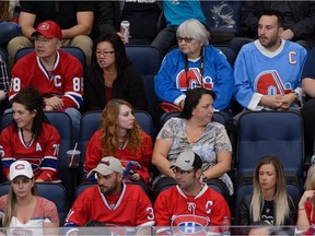 A pair of Quebec Nordiques supporters sit amongst a group of Canadiens fans during an NHL pre-season game between the Canadiens and the Pittsburgh Penguins at Centre Vidéotron in Quebec City on Sept. 28, 2015.