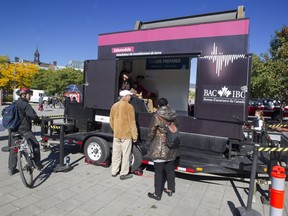 Passers-by and an an Insurance Bureau of Canada team watch as a mobile earthquake simulator is used at the Jacques-Cartier Pier at the Old Port in Montreal, Monday October 10, 2016.  The 2-day demonstration, set up by the Insurance Bureau, is meant to give people a chance to feel what 30 seconds in an earthquake measuring 8.0 on the Richter scale feels like, and to raise awareness about how to protect one's self in an earthquake. (Phil Carpenter / MONTREAL GAZETTE) ORG XMIT: 1011 city earthquake