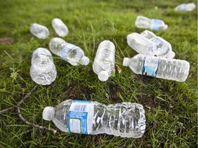 Empty water plastic bottles left as garbage on the grass outside an office building in Lachine in Montreal on Saturday, May 26, 2012. environmental crisis