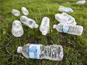 Empty water plastic bottles left as garbage on the grass outside an office building in Lachine.