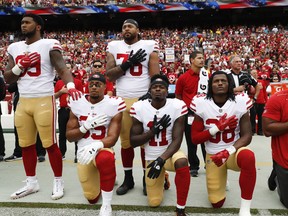 Eric Reid (second from left) and other members of the San Francisco 49ers kneel during the national anthem before a game against Washington on Oct. 15, 2017.