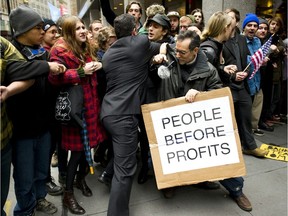 A businessman tries to break through a line of Occupy Wall Street protesters who had locked arms and blocked access to the New York Stock Exchange area November 17, 2011 in New York.  Some 1,000 protesters converged on Wall Street Thursday, and fights erupted outside the New York Stock Exchange amid a tense face-off with police. Demonstrators scuffled with men in business suits trying to push their way through the throngs on the way to work at the start of a day of protests in a show of force by the Occupy Wall Street movement. AFP PHOTO/DON EMMERT