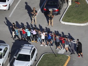 People are brought out of the Marjory Stoneman Douglas High School after a shooting at the school on Feb. 14, 2018 in Parkland, Florida.