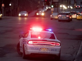 MONTREAL, QUE.: APRIL 18, 2018-- A police car blocks one lane of Peel Street as he speaks with a man in a wheelchair in Montreal on Wednesday April 18, 2018. (Allen McInnis / MONTREAL GAZETTE) ORG XMIT: 60512