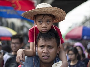 PHILIPPINES" A child sits on the shoulders of an activist as they march towards the presidential Malacanang palace in Manila on May Day 2018.