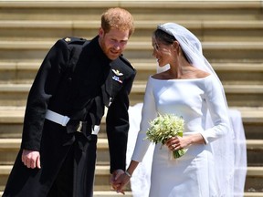 Britain's Prince Harry, Duke of Sussex and his wife Meghan, Duchess of Sussex walk down the west steps of St George's Chapel, Windsor Castle, in Windsor, on Saturday, May 19, 2018, after their wedding ceremony.