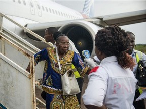 A health official uses a thermometer to measure the temperature of disembarking passengers at the airport at Mbandaka in the Democratic Republic of Congo on May 19, 2018.