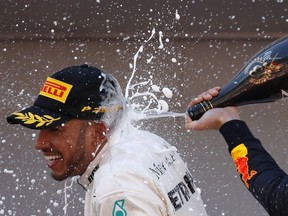 Winner Mercedes driver Lewis Hamilton of Britain sprays champagne, left, flanked by third place Red Bull driver Max Verstappen of the Netherlands, on the podium after the Spanish Formula One Grand Prix at the Barcelona Catalunya racetrack in Montmelo, Spain, Sunday, May 13, 2018.