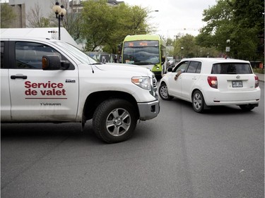 MONTREAL, QUE.: MAY 23, 2018-- A val;et service vehicle forces his way in to traffic as a motorist pulls infant of an STM bus to line up for valet parking during the C2 event in Montreal on Wednesday May 23, 2018. The STM bus was forced to stop while until the vehicles cleared the street. (Allen McInnis / MONTREAL GAZETTE) ORG XMIT: 60727