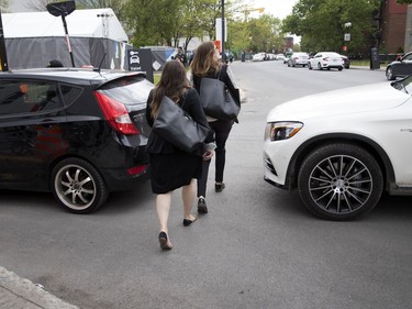 MONTREAL, QUE.: MAY 23, 2018-- Pedestrians squeeze between cars as the block the streets lining up for valet parking during the C2 event in Montreal on Wednesday May 23, 2018. Two pedestrians narrowly avoided being struck by vehicles while a Gazette photographer was on the scene. (Allen McInnis / MONTREAL GAZETTE) ORG XMIT: 60727