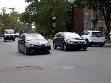 MONTREAL, QUE.: MAY 23, 2018-- A motorist, right, crosses the solid yellow line to speed past a very slow moving car during the C2 event in Montreal on Wednesday May 23, 2018. The slow moving car, left, appeared to be slowing trolling for a parking spot. (Allen McInnis / MONTREAL GAZETTE) ORG XMIT: 60727