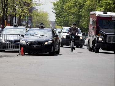 MONTREAL, QUE.: MAY 23, 2018-- A Garda armoured truck completely enters the westbound lane as he passes a cyclist who passes a double parked taxi during the C2 event in Montreal on Wednesday May 23, 2018. (Allen McInnis / MONTREAL GAZETTE) ORG XMIT: 60727