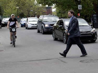 MONTREAL, QUE.: MAY 23, 2018-- A pedestrian jaywalks causing traffic and cyclists to slow during the C2 event in Montreal on Wednesday May 23, 2018. Two pedestrians narrowly avoided being struck by vehicles while a Gazette photographer was on the scene. (Allen McInnis / MONTREAL GAZETTE) ORG XMIT: 60727