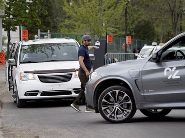 MONTREAL, QUE.: MAY 23, 2018-- A parking lot worker walks out into Notre-Dame Street forcing traffic to stop to allow vehicles to enter the VIP parking area during the C2 event in Montreal on Wednesday May 23, 2018. (Allen McInnis / MONTREAL GAZETTE) ORG XMIT: 60727