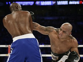 Oscar Rivas of Montreal connects against Sawn Cox of Trinidad and Tobago, left, during their heavyweight fight at the Bell Centre in Montreal on Jan. 18, 2014. Rivas won by TKO.