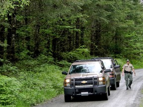 Washington State Fish and Wildlife Police leave the scene on a remote King County road near the site of a fatal cougar attack on Saturday, May 19, 2018, in East King County, Wash.