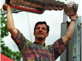 Montreal Canadiens captain Guy Carbonneau holds the Stanley Cup during a parade in Montreal on June 11, 1993.