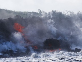 Lava flows into the ocean near Pahoa, Hawaii, Sunday, May 20, 2018. Kilauea volcano that is oozing, spewing and exploding on Hawaii's Big Island has gotten more hazardous in recent days, with rivers of molten rock pouring into the ocean Sunday and flying lava causing the first major injury.