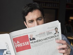A man reads the final print edition of the French language newspaper La Presse Dec. 30, 2017.