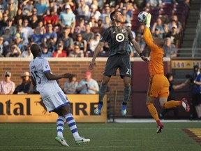 Minnesota United forward Christian Ramirez (21) goes up for a head ball as Montreal Impact goalkeeper Evan Bush (1) makes a leaping save during the first half on May 26, 2018, in Minneapolis.