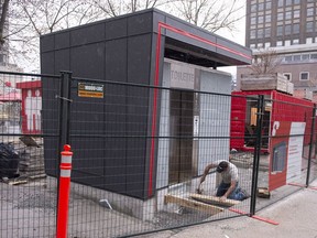 A worker puts the finishing touches on a new public toilet in Montreal, Thursday, May 3, 2018.