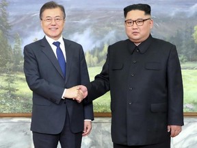 In this photo provided by South Korea Presidential Blue House via Yonhap News Agency, North Korean leader Kim Jong Un, right, and South Korean President Moon Jae-in, left, shake hands before their meeting at the northern side of the Panmunjom in North Korea, Saturday, May 26, 2018.