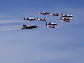 The Royal Canadian Air Force's CF-18 Hornet demonstration fighter jet, piloted by Capt. Ryan Kean, flies in formation with the CT-114 Tutor jets of the Snowbirds team over CFB Trenton, Ont. Thursday, June 23, 2016.