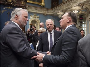 Premier Philippe Couillard, left, shakes hand with Coalition Avenir Québec Leader François Legault as Parti Québécois Leader Jean-François Lisée, centre looks on, after they gave their season's greetings to Quebecers from the National Assembly, in Quebec City on Friday, December 9, 2016.
