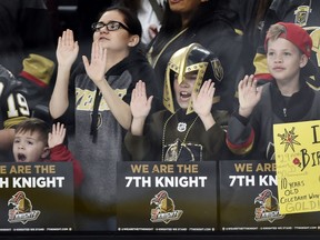 In this Feb. 13, 2018, file photo, young Vegas Golden Knights fans cheers before the start an NHL hockey game between the Vegas Golden Knights and the Chicago Blackhawks  in Las Vegas. The love affair between a city and its new team wasn't totally unexpected. Las Vegas was, after all, a town starved for major league sports.
