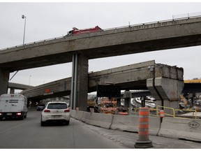 Cars make their west on a new section of the Ville-Marie Expressway as a partially demolished section of the old span remains in Montreal Friday March 2, 2018.