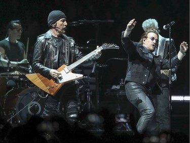 U2 in concert at the Bell Centre in Montreal Tuesday June 5, 2018. Drummer Larry Mullin, Jr., The Edge on guitar, Bono on vocals and Adam Clayton, obscured, on bass.