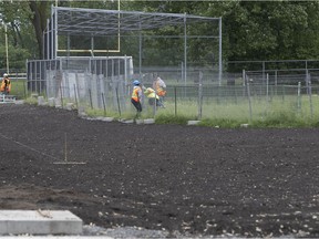 Workers on the field near the softball diamond in the northern part of Jeanne Mance park on Tuesday June 5, 2018.