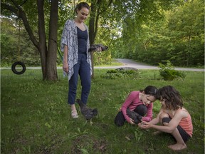 Kirsten Bowser with two of her children, Greta and Ingrid (right), with a pair of the family's chickens they are raising at their Hudson home.