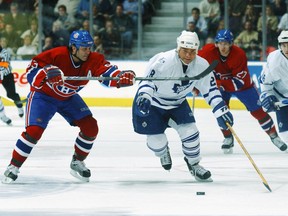 Tie Domi of the Toronto Maple Leafs chases after lose puck while being checked by the Canadiens’ Doug Gilmour during NHL game at the Air Canada Centre on Feb. 8, 2003.
