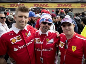 Ferrari fans Patrick Giguère, from left, Renaud Bégin and  Lorenzo Laurieri stand outside the Ferrari pits during the open house event at Circuit Gilles Villeneuve in Montreal on Thursday June 7, 2018.