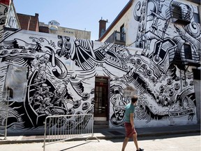A pedestrian looks at the work of Jason Wasserman on Duluth Street as part of last year's edition of Mural Fest in Montreal on Wednesday June 14, 2017.