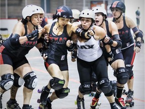 A jammer, second from left, from the Texas Rollergirls Texecutioners tries to break free from the pack despite opposition from the Jacksonville Roller Derby New Jax City Rollers during game in the inaugural Georgia W. Tush roller derby tournament in Montreal Sunday June 17, 2018.