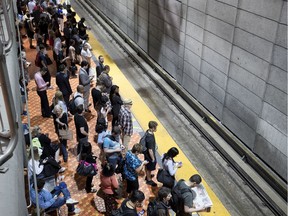 A crowd waits for a train on the Green metro line in Montreal on Tuesday June 19, 2018.