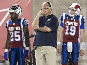 Montreal Alouettes head coach Mike Sherman looks concerned on the play in the fourth quarter while standing between Dondre Wright (25) and Garrett Fugate (19) as the Alouettes went on to lose the game against the Winnipeg Blue Bombers 56-10, at Molson Stadium on Friday June 22, 2018.